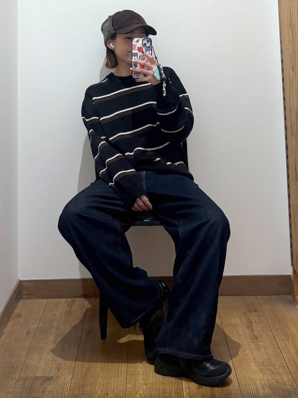 ブラック系のデニムパンツを着用したレディースの冬コーディネートの1枚目の写真