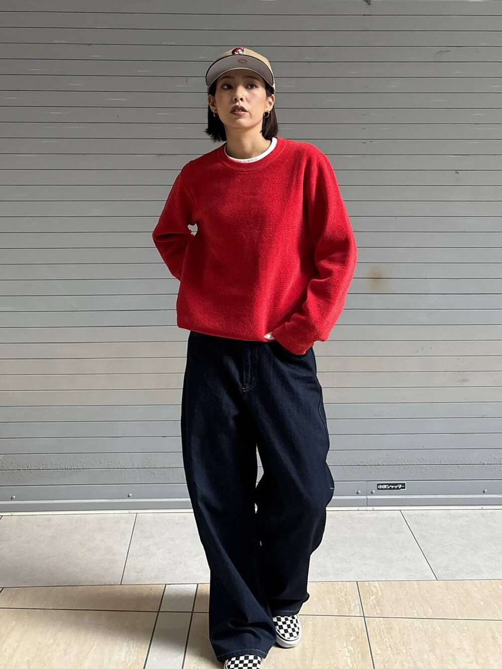 ブルー系のデニムパンツ、レッド系のニット/セーターを着用したレディースの秋コーディネートの1枚目の写真