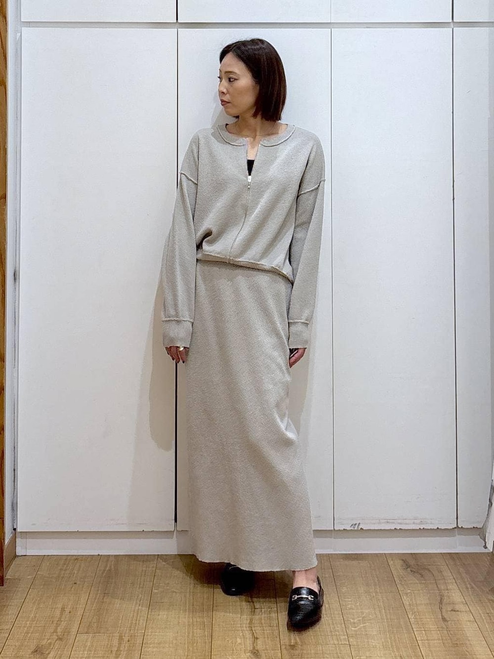 ブラック系のローファー、ベージュ系のワンピース、ゴールド系のピアス(両耳用)を着用したレディースの冬コーディネートの1枚目の写真