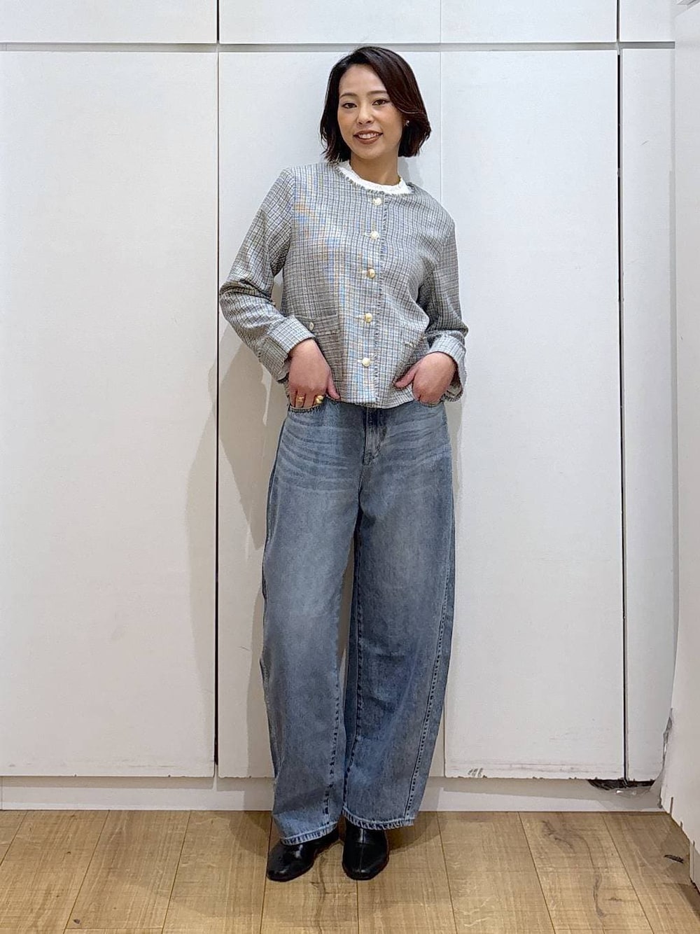 ブラック系のセットアップ、ホワイト系のテーラードジャケット、ブラック系のブーツを着用したレディースの冬コーディネートの1枚目の写真