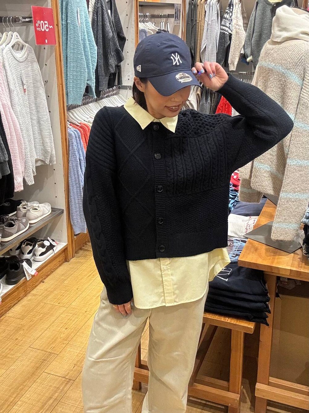 ベージュ系のデニムパンツ、イエロー系のシャツ/ブラウス、ブルー系のカーディガン/ボレロを着用したレディースの冬コーディネートの1枚目の写真