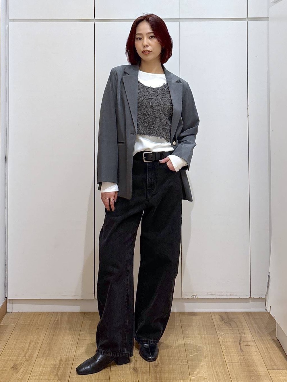 グレー系のテーラードジャケット、ブラック系のブーツ、ブラック系のデニムパンツを着用したレディースの春コーディネートの1枚目の写真