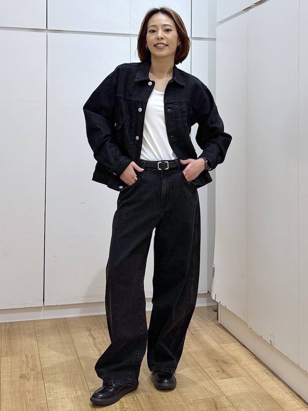 ブラック系のデニムパンツ、ブラック系のデニムジャケット、ホワイト系のキャミソールを着用したレディースの春コーディネートの1枚目の写真