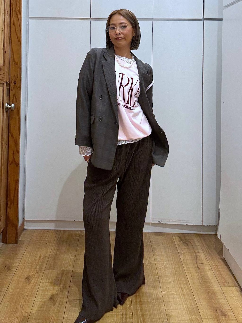 パープル系のボストンバッグ、ホワイト系のTシャツ/カットソー、ブラウン系のテーラードジャケットを着用したレディースの秋コーディネートの1枚目の写真
