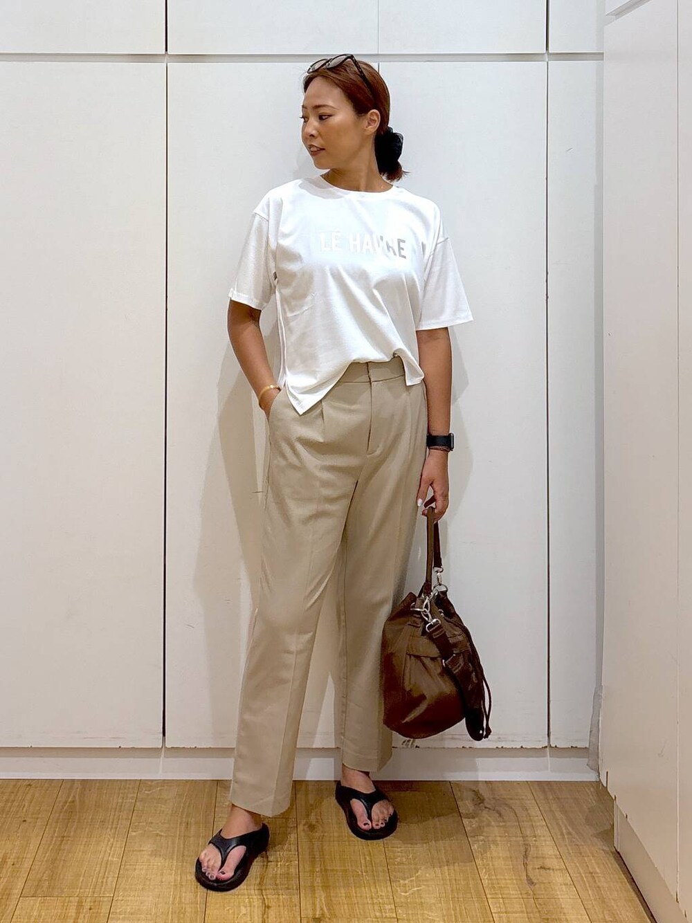 ホワイト系のTシャツ/カットソー、ブラック系のサンダル、ベージュ系のその他パンツを着用したレディースの夏コーディネートの1枚目の写真