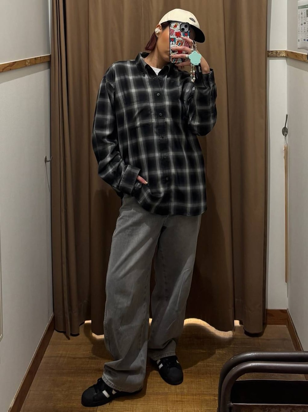 グレー系のデニムパンツ、ブラック系のシャツ/ブラウス、ベージュ系のキャップを着用したレディースの春コーディネートの1枚目の写真