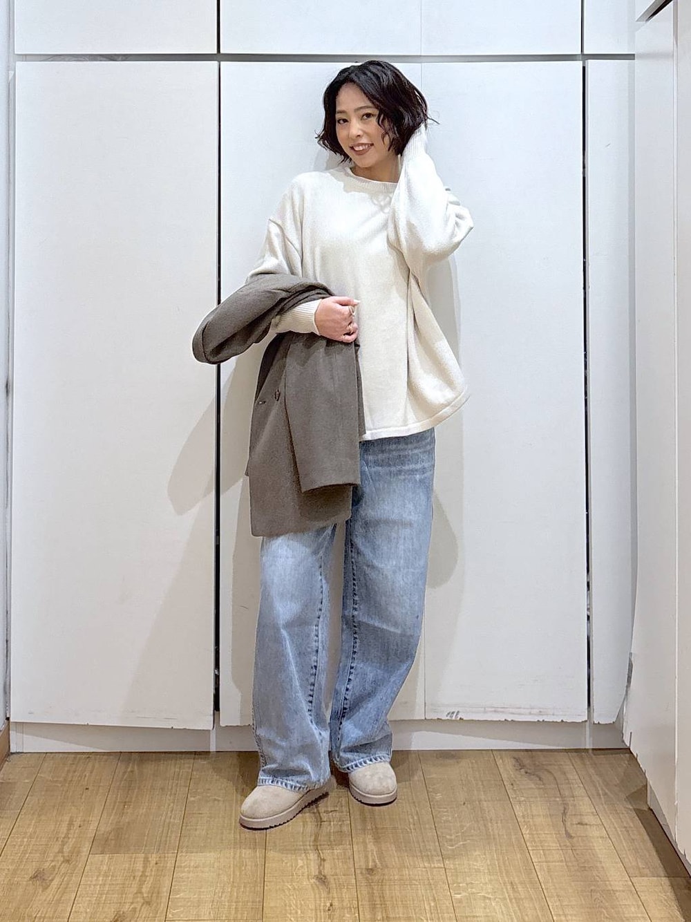 ブラック系のニット/セーター、ブルー系のデニムパンツ、ホワイト系のTシャツ/カットソーを着用したレディースの冬コーディネートの1枚目の写真