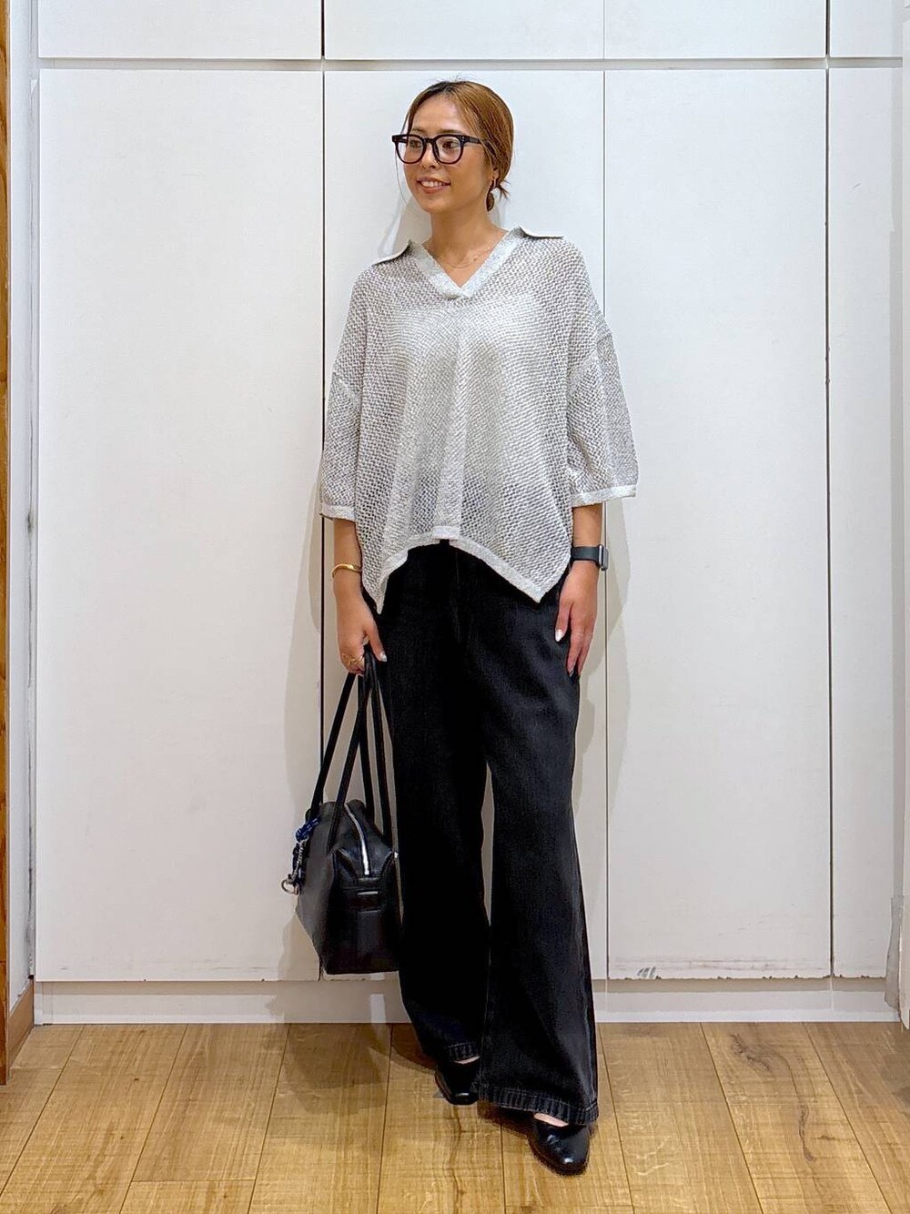 ブラック系のパンプス、ホワイト系のキャミソール、ブラック系のボストンバッグを着用したレディースの秋コーディネートの1枚目の写真