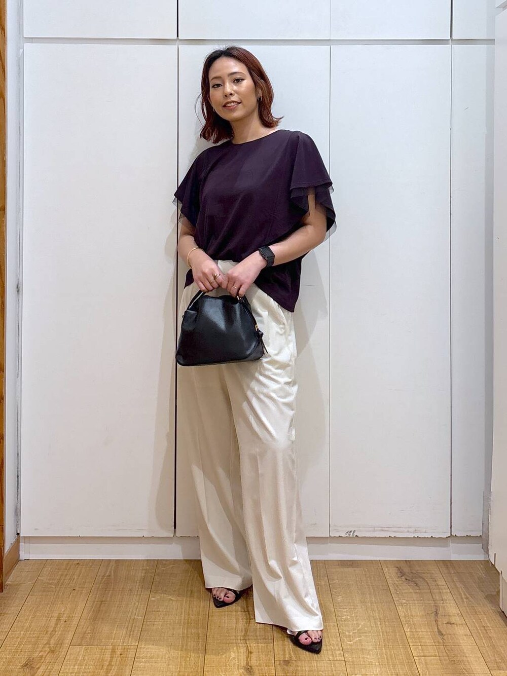 ブラック系のショルダーバッグ、ホワイト系のその他パンツ、ブラウン系のTシャツ/カットソーを着用したレディースの夏コーディネートの1枚目の写真