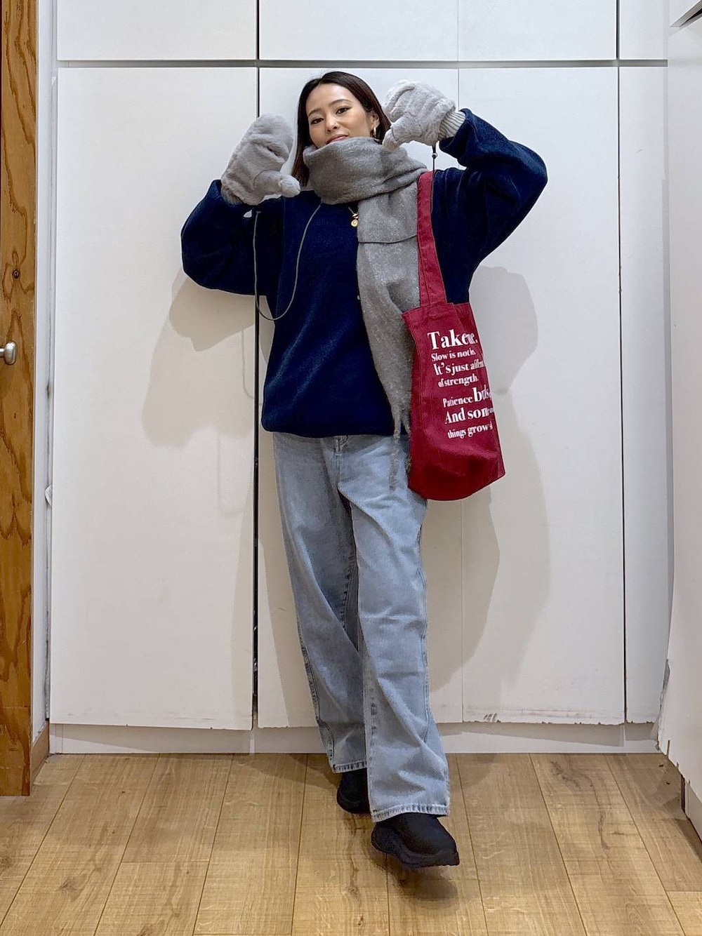 ブルー系のデニムパンツ、ホワイト系のTシャツ/カットソー、レッド系のトートバッグを着用したレディースの冬コーディネートの1枚目の写真