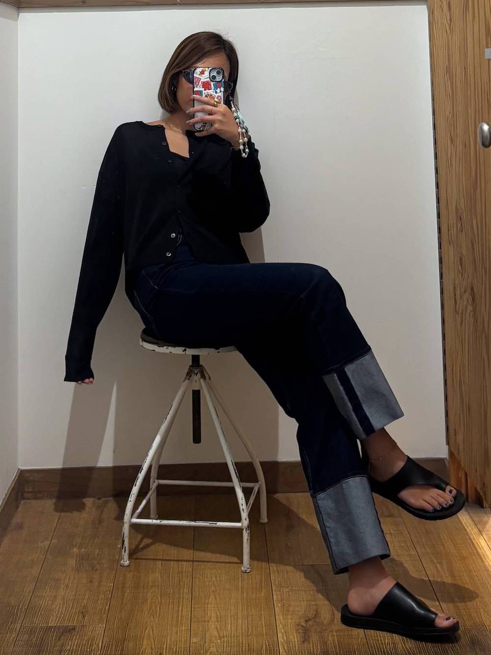 ブルー系のデニムパンツ、ブラック系のキャミソール、ブラック系のカーディガン/ボレロを着用したレディースの秋コーディネートの1枚目の写真