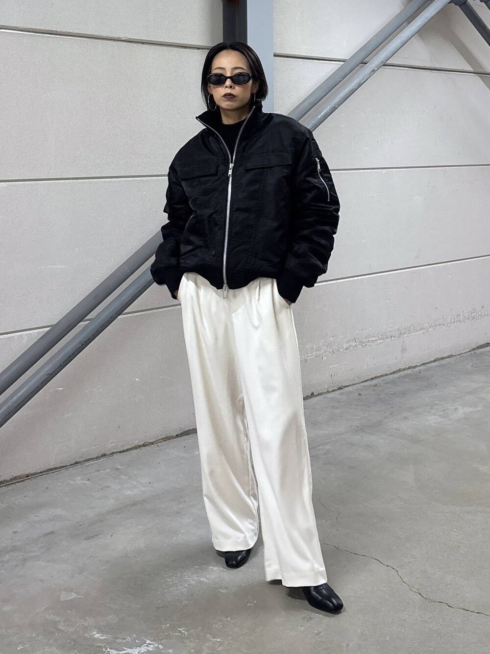 ブラック系のニット/セーター、グレー系のその他パンツ、ブラック系のブーツを着用したレディースの秋コーディネートの1枚目の写真