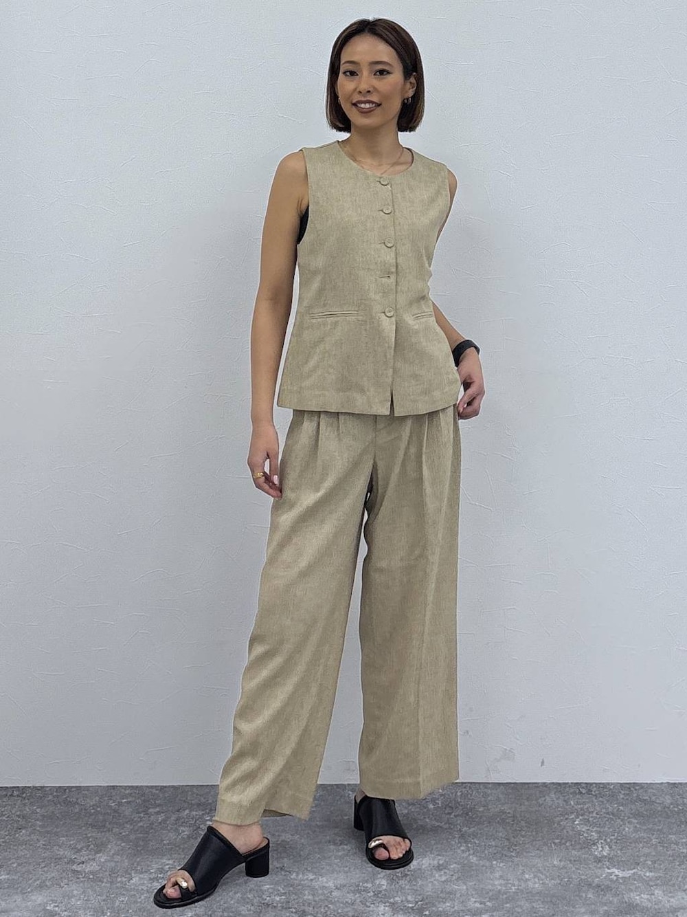 ベージュ系のその他パンツ、ベージュ系のベスト、ゴールド系のネックレスを着用したレディースの春コーディネートの1枚目の写真