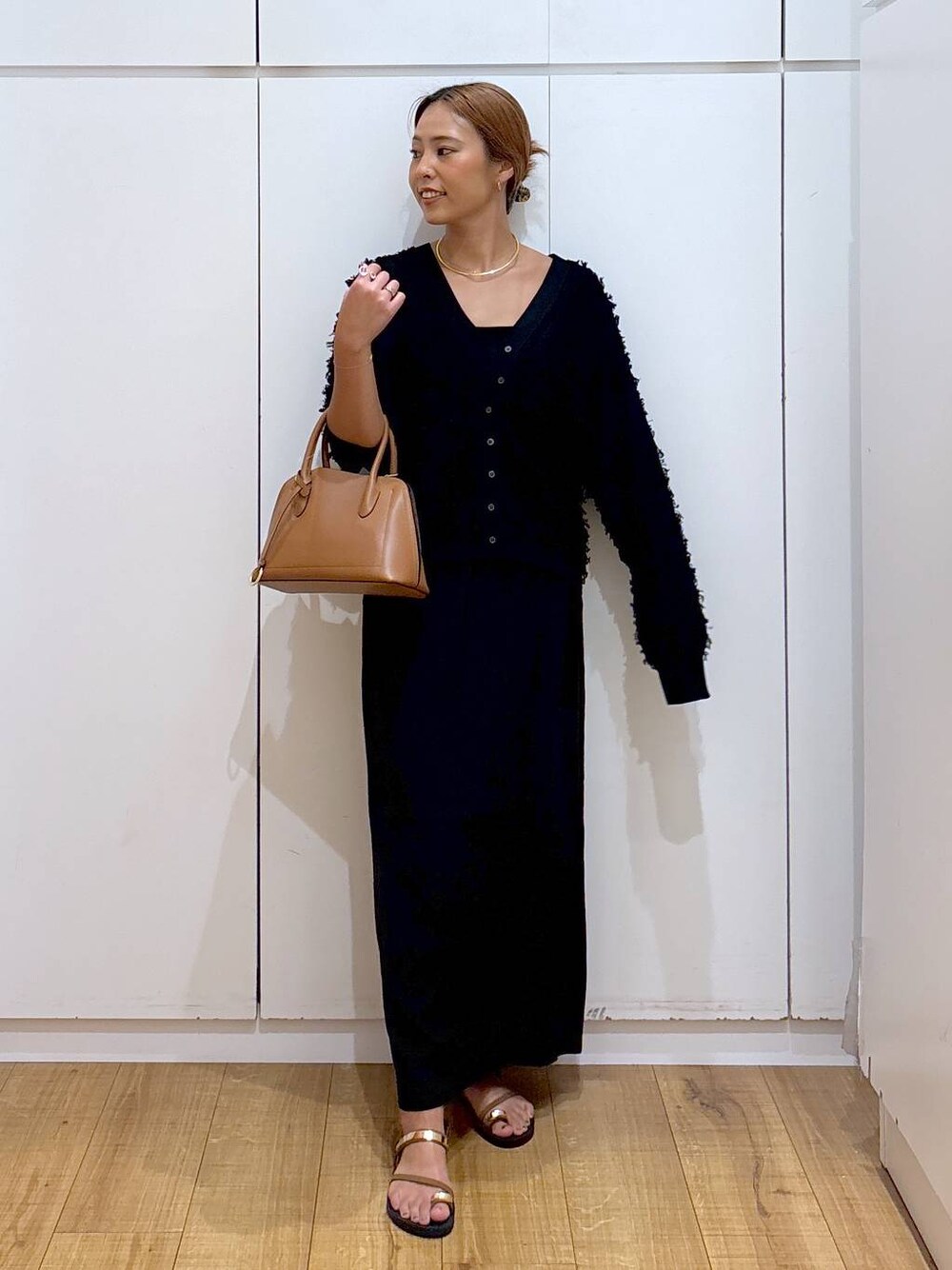 ブラウン系のショルダーバッグ、ブラック系のキャミソール、ブラウン系のサンダルを着用したレディースの秋コーディネートの1枚目の写真