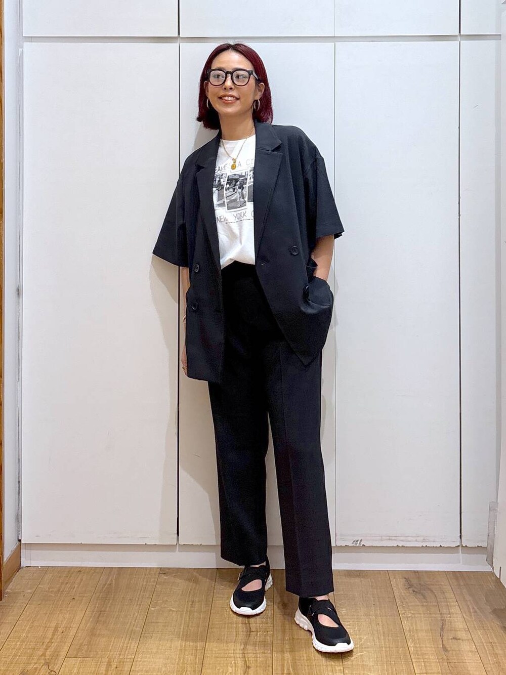 ブラック系のスニーカー、ブラック系のテーラードジャケット、ホワイト系のTシャツ/カットソーを着用したレディースの春コーディネートの1枚目の写真