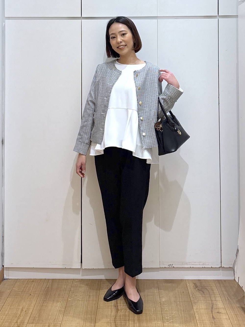 ブラック系のショルダーバッグ、ブラック系のパンプス、ブラック系のスラックスを着用したレディースの冬コーディネートの1枚目の写真