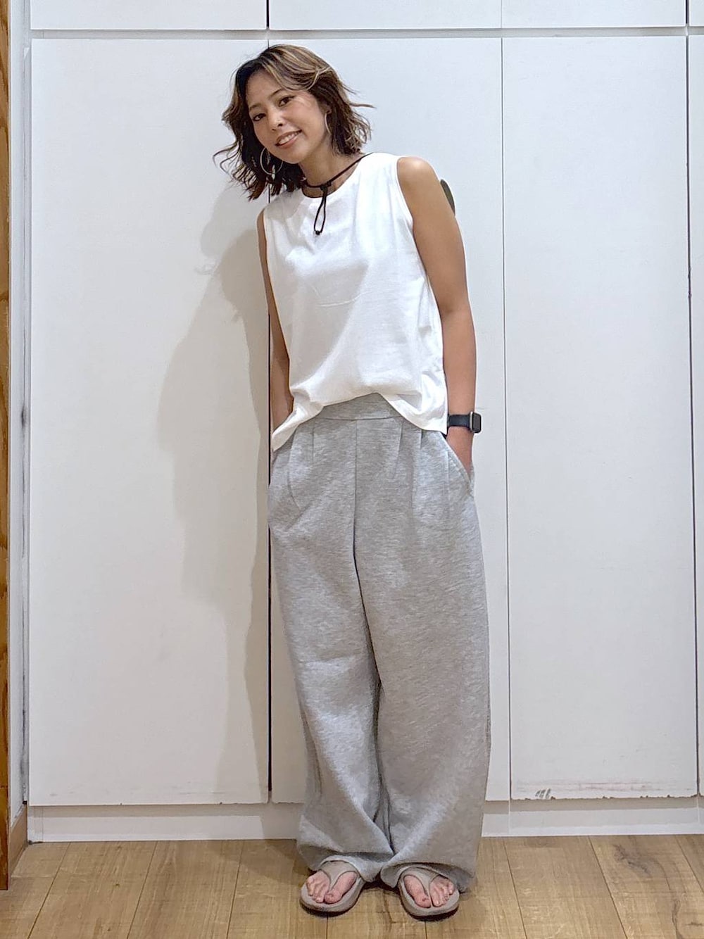 その他のタンクトップ、グレー系のその他パンツ、ベージュ系のサンダルを着用したレディースの夏コーディネートの1枚目の写真