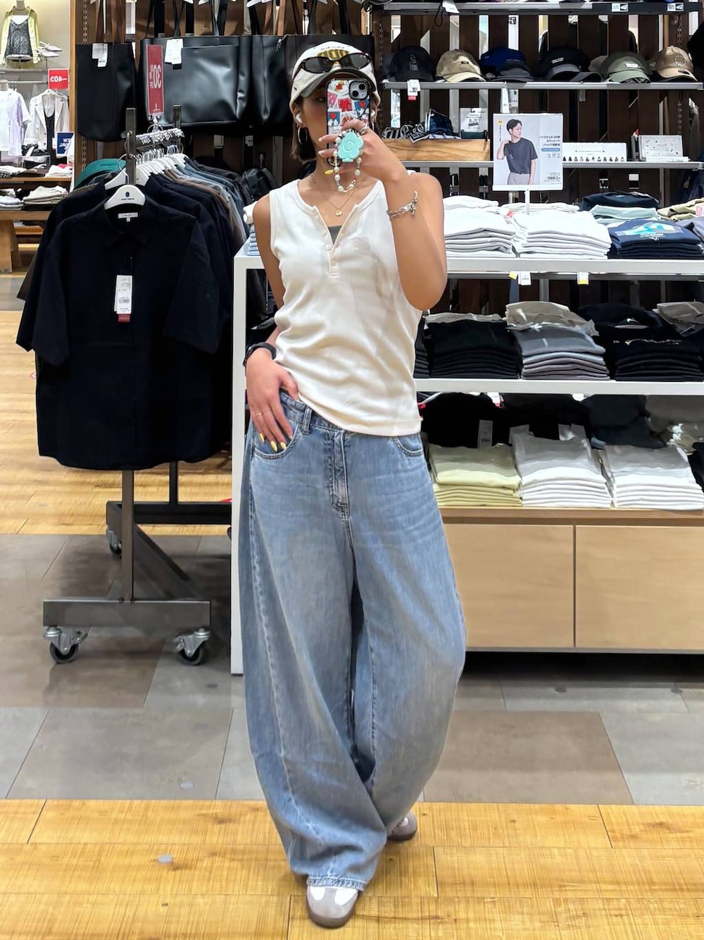 ブルー系のデニムパンツ、ホワイト系のタンクトップを着用したレディースの夏コーディネートの1枚目の写真
