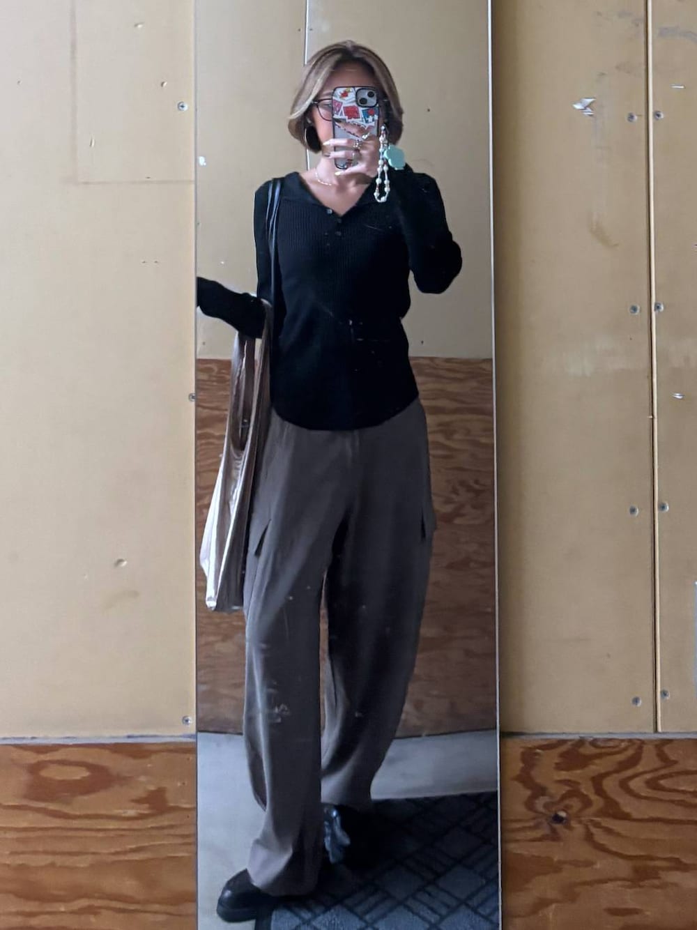 ブラック系のパーカー、グリーン系のその他パンツ、ブラック系のローファーを着用したレディースの秋コーディネートの1枚目の写真
