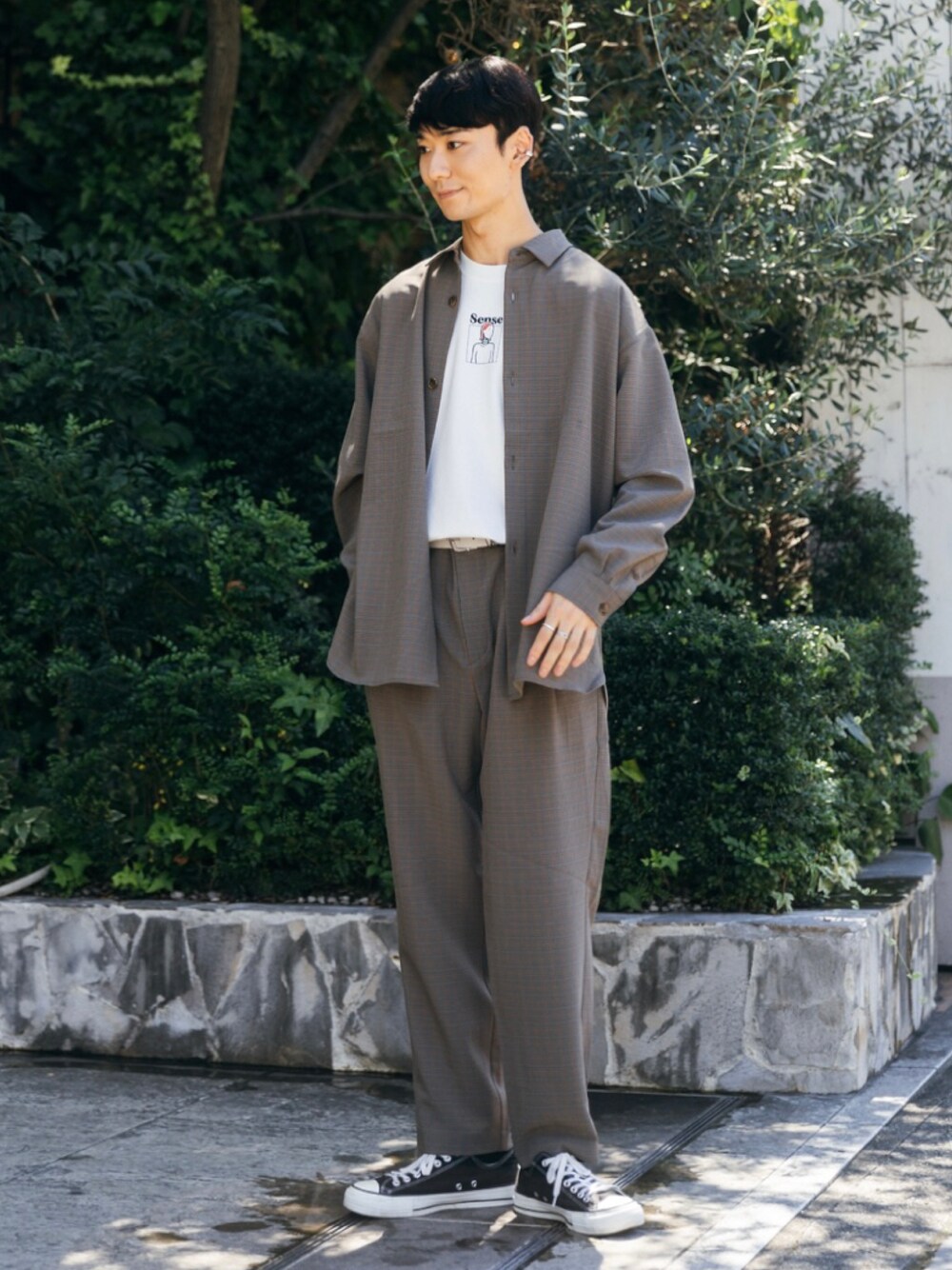 ブラック系のスニーカー、ホワイト系のTシャツ/カットソー、ベージュ系のスラックスを着用したメンズの夏コーディネートの1枚目の写真