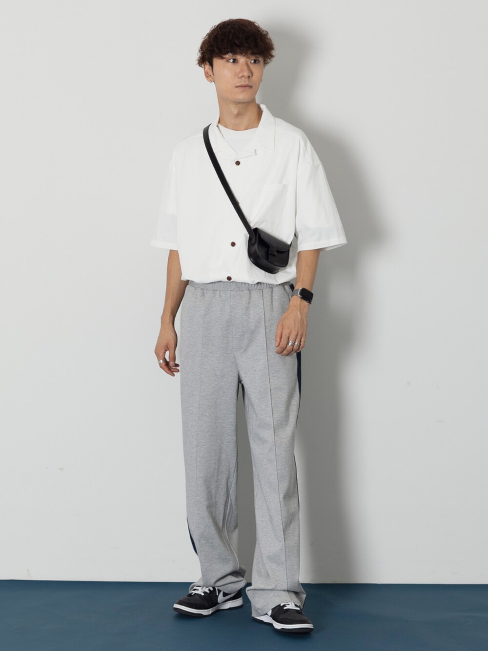 ホワイト系のシャツ/ブラウス、ブラック系のショルダーバッグ、ブラック系のスニーカーを着用したメンズの秋コーディネートの1枚目の写真