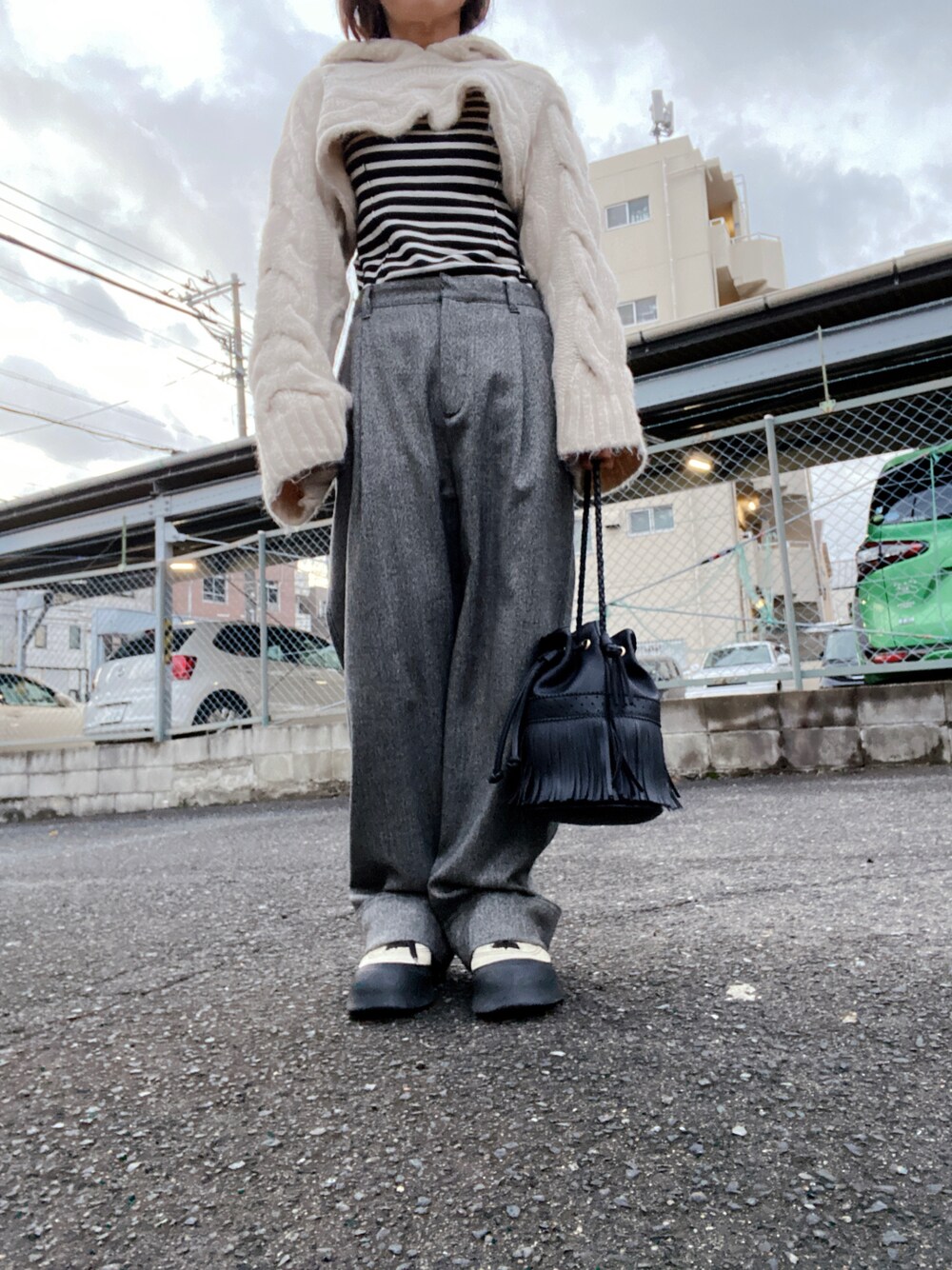 ホワイト系のニット/セーター、ブラック系のニット/セーター、グレー系のパンツを着用したレディースの冬コーディネートの1枚目の写真