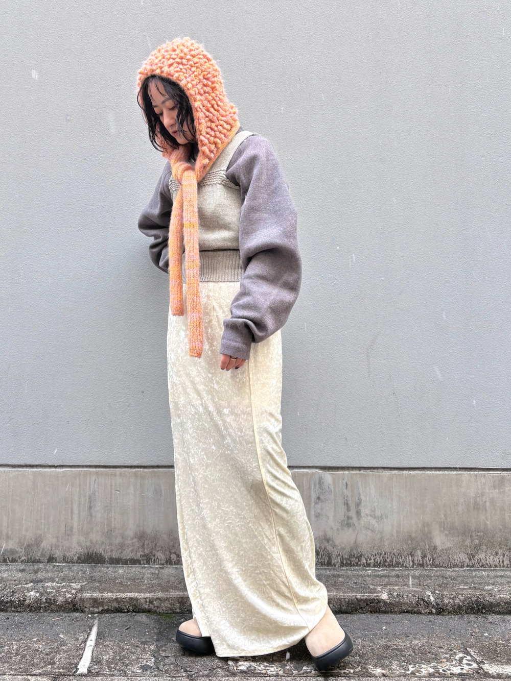 オレンジ系のニットキャップ/ビーニーを着用したレディースの冬コーディネートの1枚目の写真