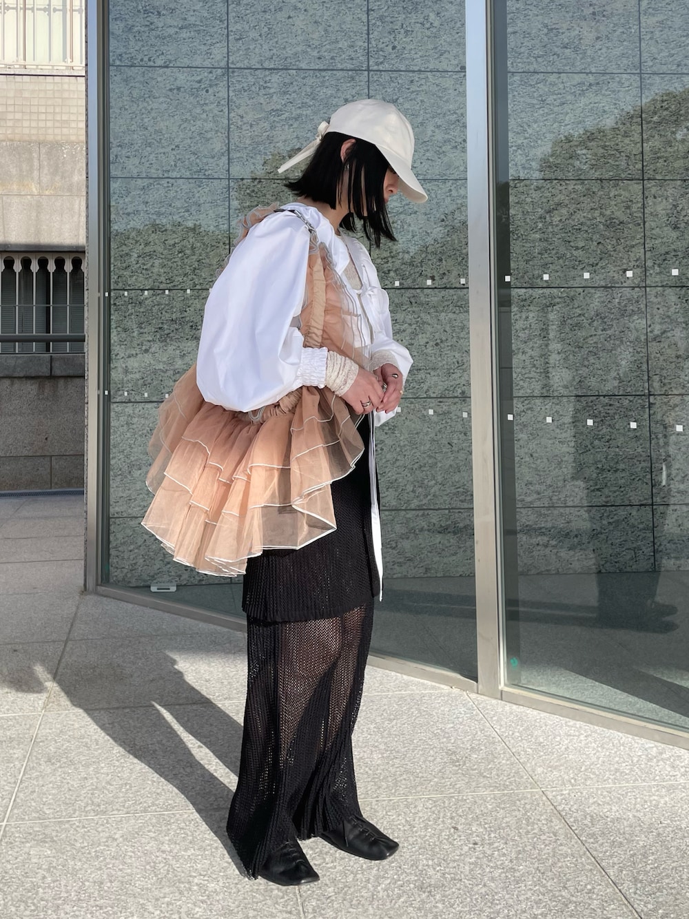 ベージュ系のボディバッグ/ウエストポーチ、ホワイト系のキャップ、ホワイト系のキャップを着用したレディースの春コーディネートの1枚目の写真