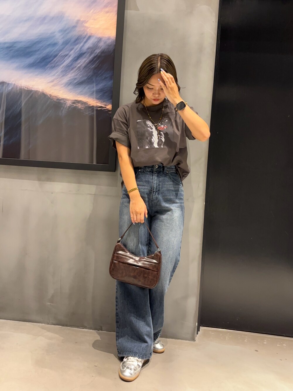ホワイト系のTシャツ/カットソー、ブルー系のデニムパンツ、ブラウン系のハンドバッグを着用したレディースの夏コーディネートの1枚目の写真