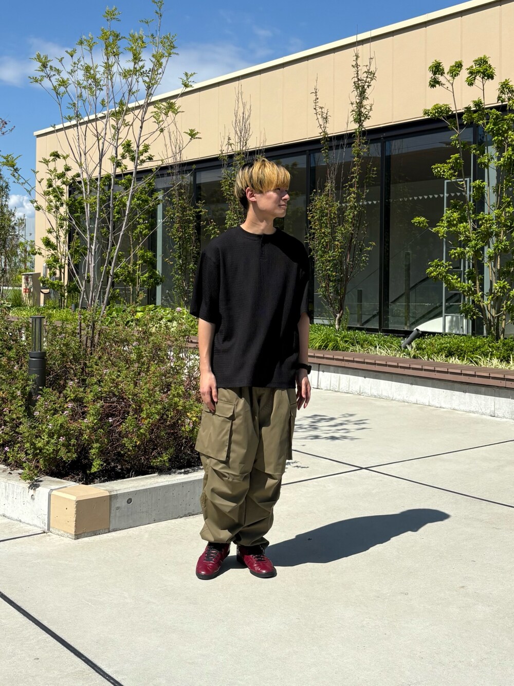 ブラック系のTシャツ/カットソー、グリーン系のカーゴパンツを着用したメンズの夏コーディネートの1枚目の写真