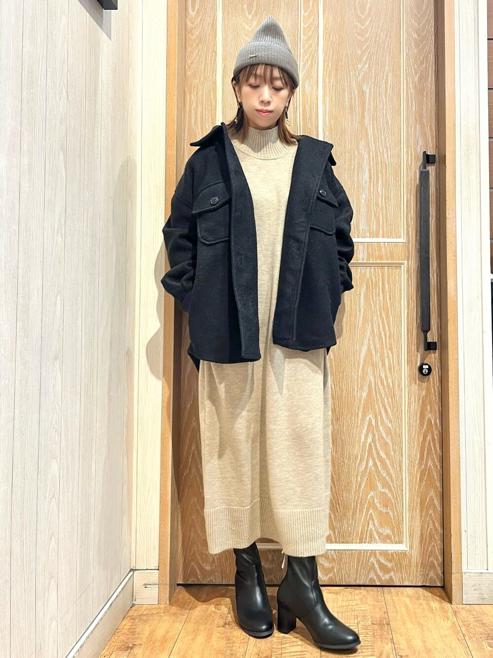 ブラック系のテーラードジャケット、ベージュ系のワンピース、ブラック系のブーツを着用したレディースの秋コーディネートの1枚目の写真