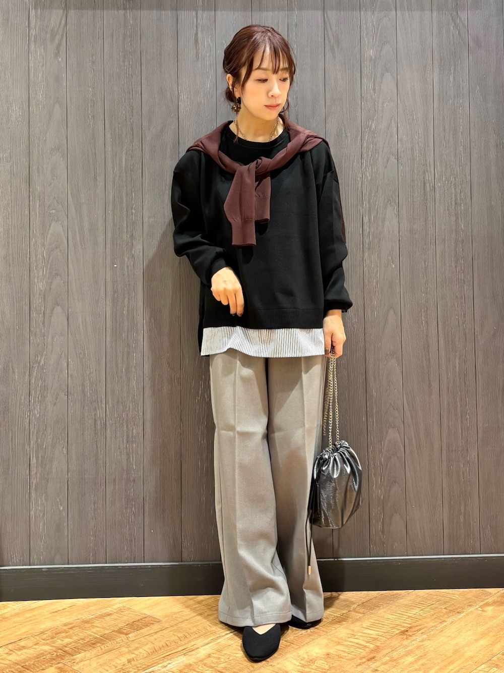 グレー系のショルダーバッグ、グレー系のその他パンツ、ブラック系のニット/セーターを着用したレディースの秋コーディネートの1枚目の写真