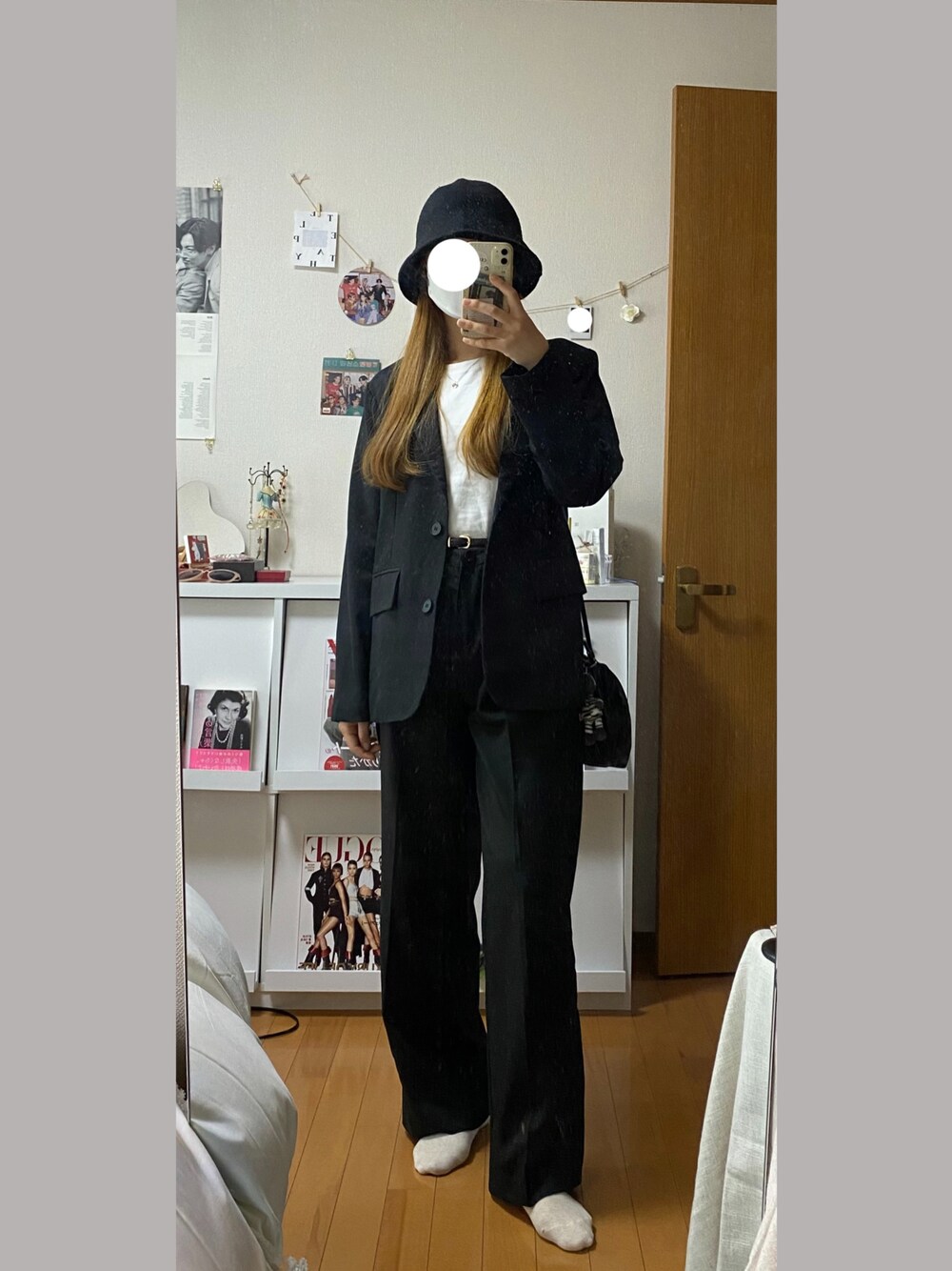 ブラック系のスラックス、ブラック系のテーラードジャケット、ブラック系のハットを着用したレディースの春コーディネートの1枚目の写真