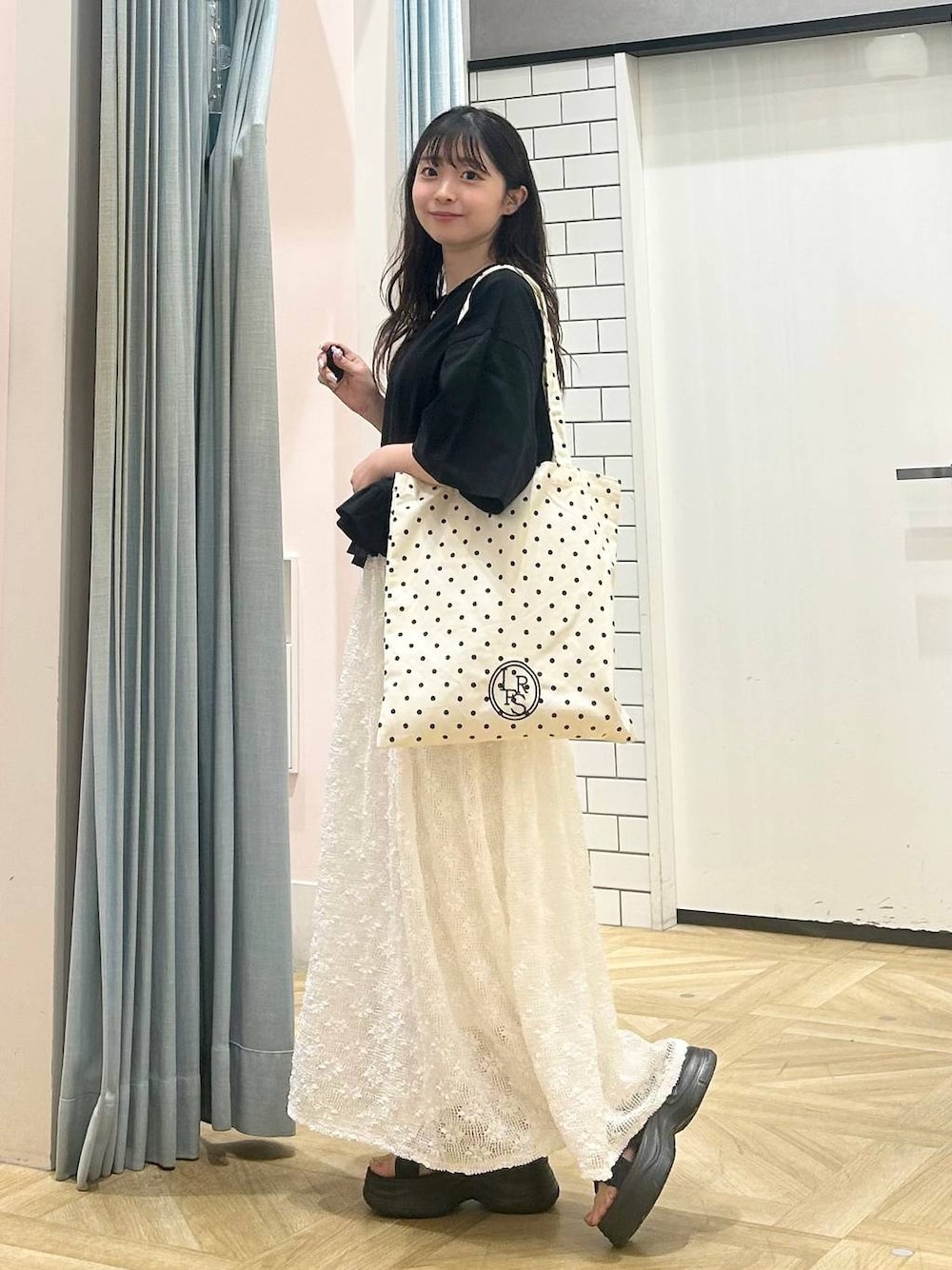 ブラック系のサンダル、その他のトートバッグ、ブラック系のTシャツ/カットソーを着用したレディースの夏コーディネートの1枚目の写真