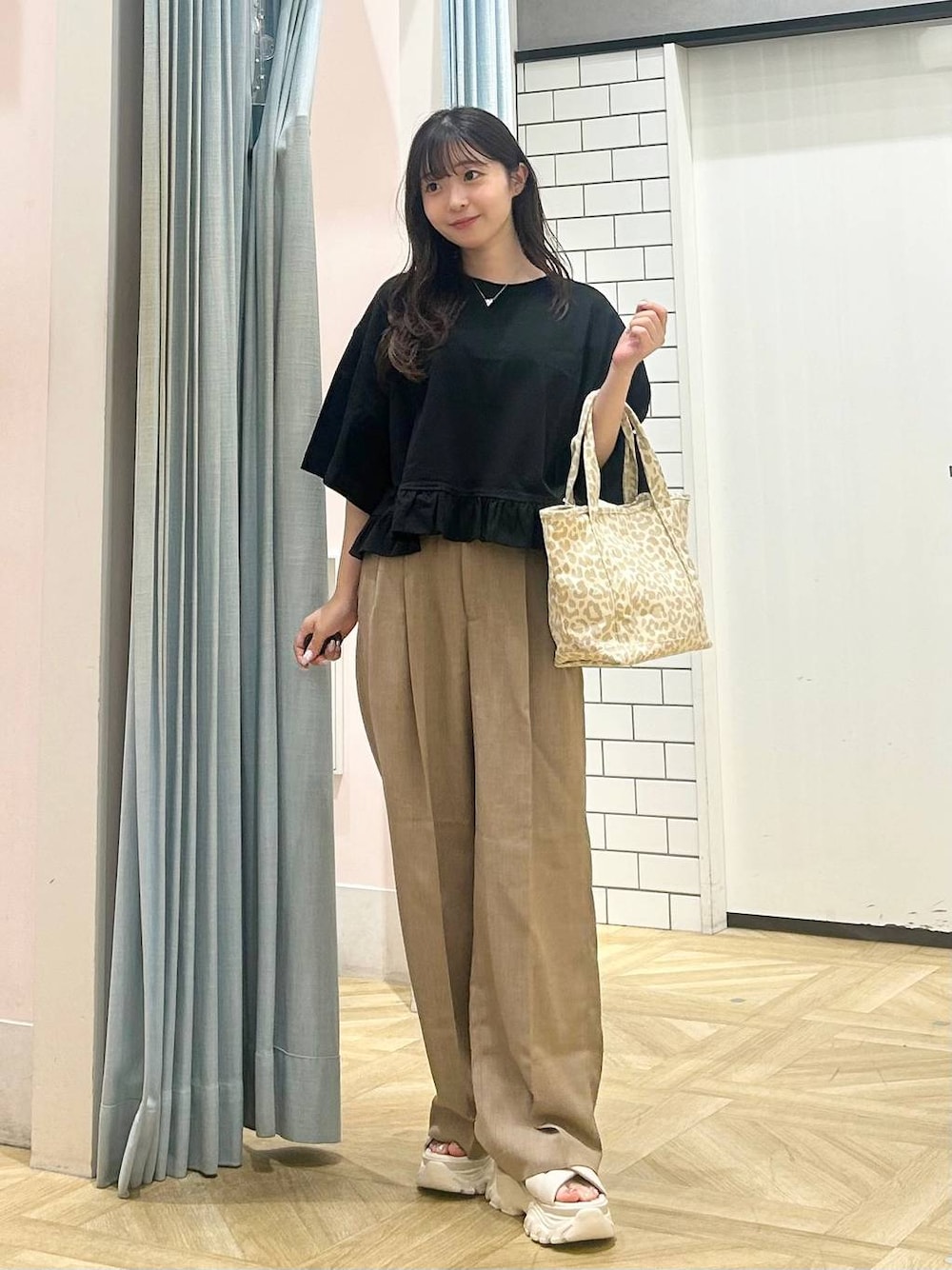 ホワイト系のサンダル、ベージュ系のショルダーバッグ、ベージュ系のスラックスを着用したレディースの夏コーディネートの1枚目の写真