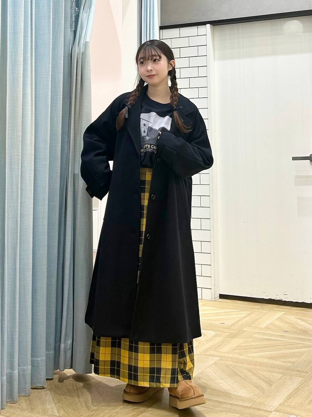 ブルー系のチェスターコート、イエロー系のスカート、ブラウン系のその他シューズを着用したレディースの秋コーディネートの1枚目の写真