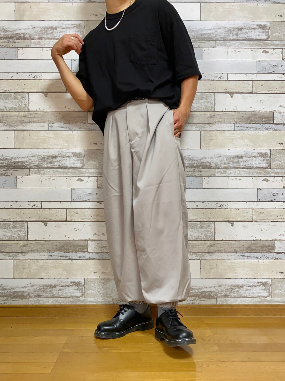 ブラック系のTシャツ/カットソー、ベージュ系のその他パンツ、ブラック系のドレスシューズを着用したメンズの秋コーディネートの1枚目の写真