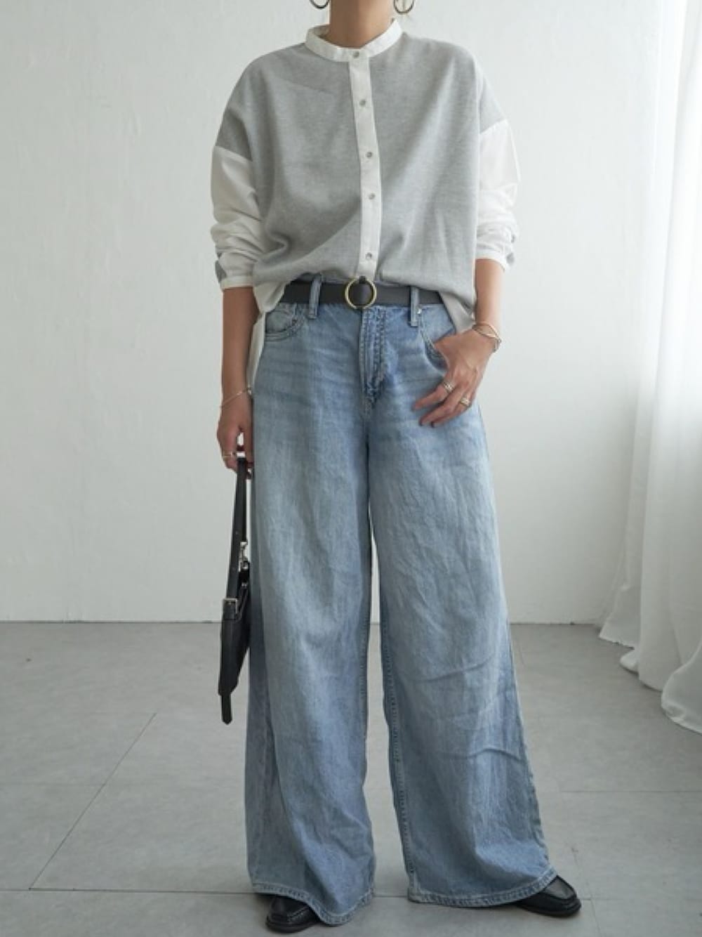 グレー系のシャツ/ブラウス、ブルー系のパンツを着用したレディースの秋コーディネートの1枚目の写真