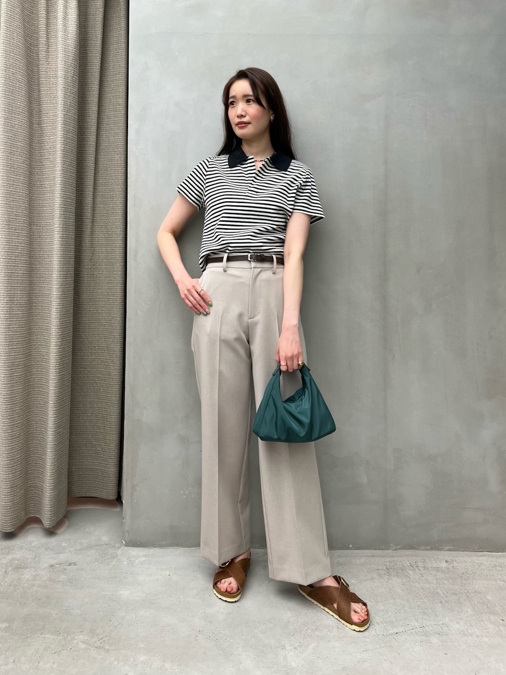 グリーン系のショルダーバッグ、ブラウン系のサンダル、その他のポロシャツを着用したレディースの夏コーディネートの1枚目の写真