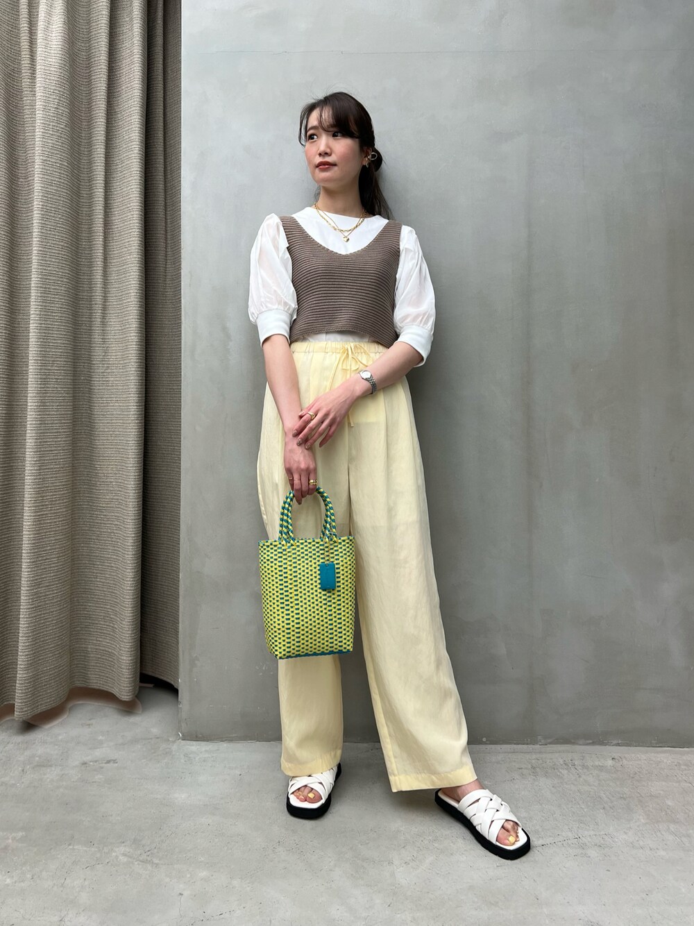 ブラウン系のキャミソール、ベージュ系のその他パンツ、イエロー系のかごバッグを着用したレディースの春コーディネートの1枚目の写真