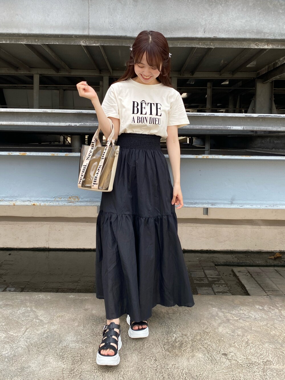 ブラック系のサンダル、ホワイト系のTシャツ/カットソー、ブラック系のスカートを着用したレディースの夏コーディネートの1枚目の写真
