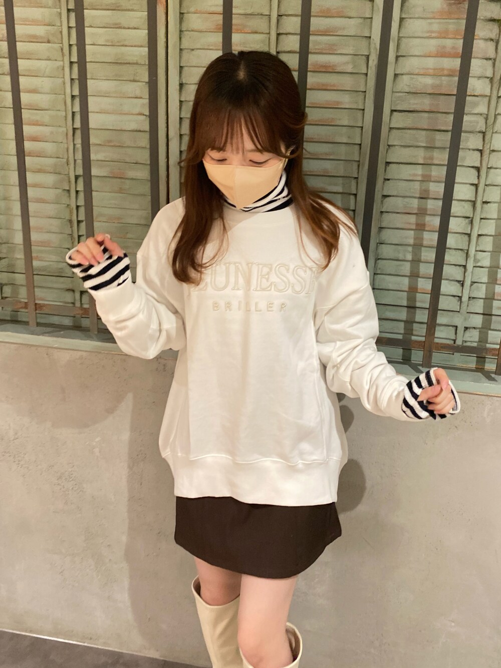 ホワイト系のスウェット、ブラック系のTシャツ/カットソー、ブラウン系のスカートを着用したレディースの秋コーディネートの1枚目の写真