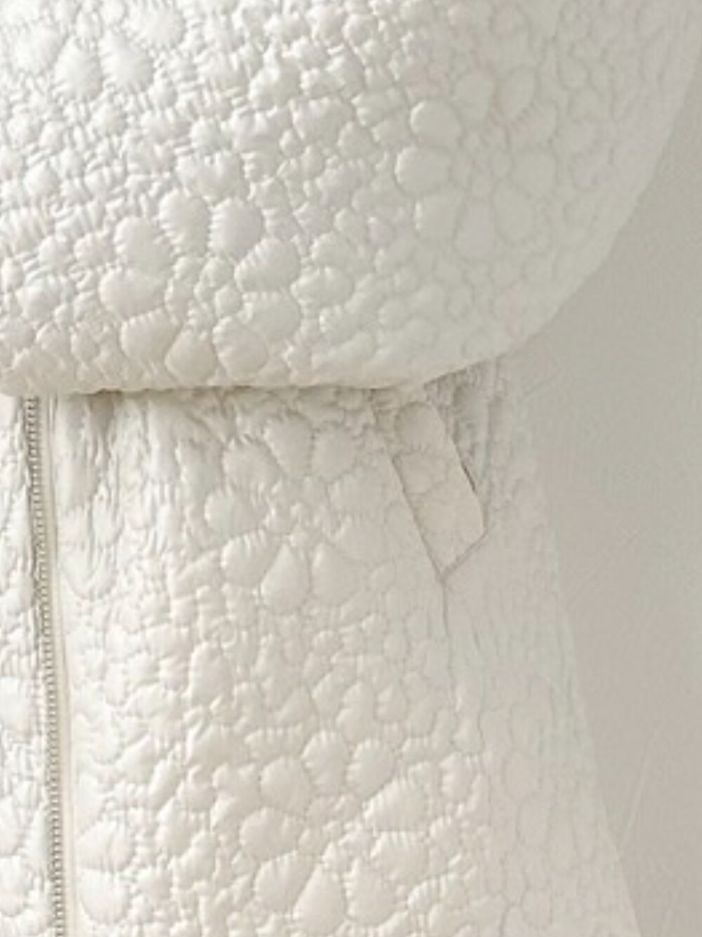 ホワイト系のノーカラージャケット、ブラック系のTシャツ/カットソー、ブラック系のパンツを着用したレディースの冬コーディネートの2枚目の写真