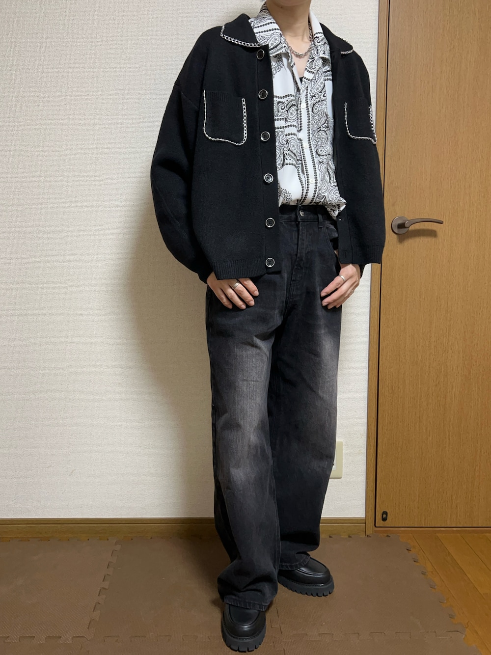 ブラック系のデニムパンツ、ブラック系のカーディガン/ボレロ、ホワイト系のシャツ/ブラウスを着用したメンズの秋コーディネートの1枚目の写真