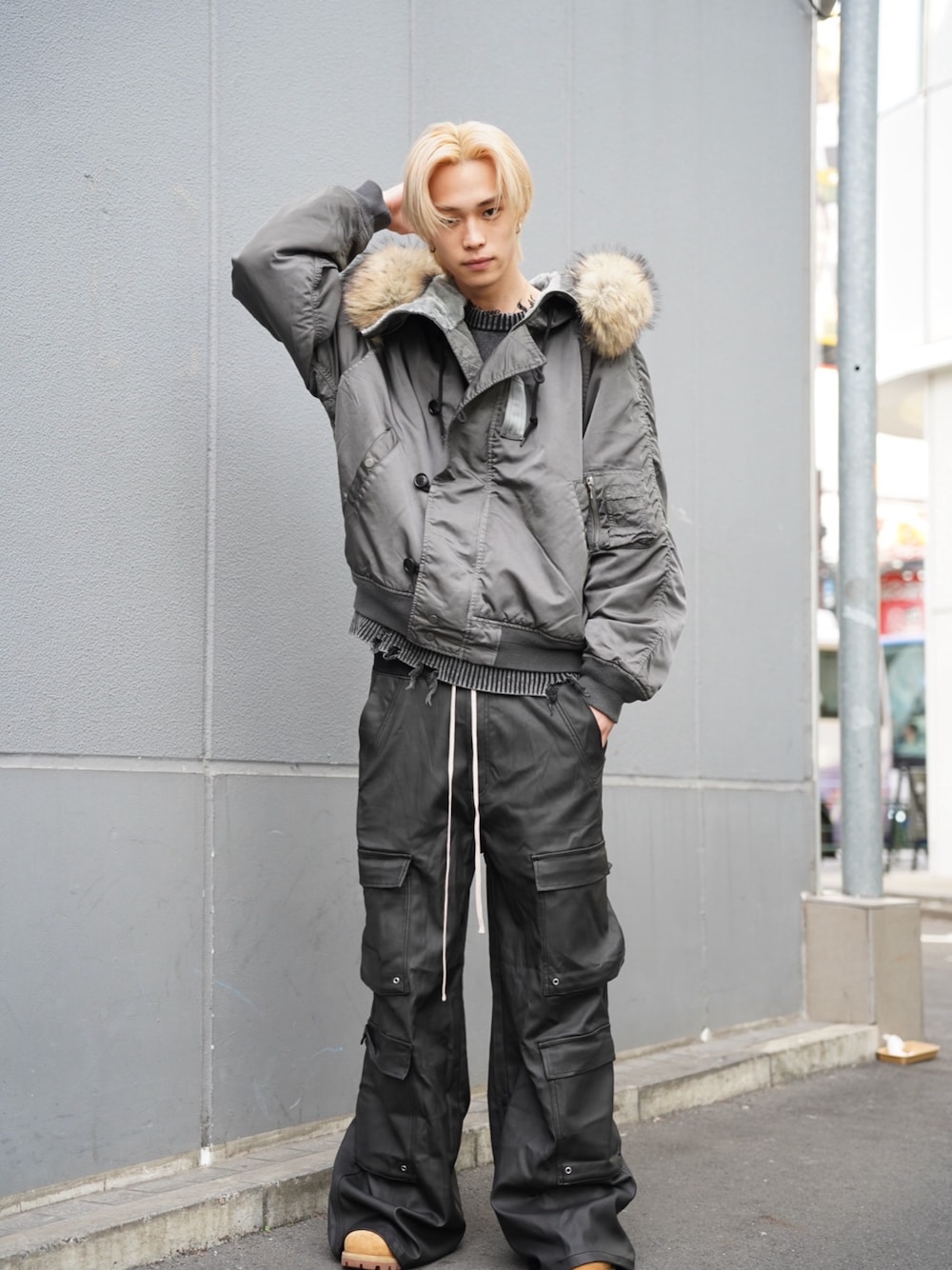 グリーン系のミリタリージャケット、ブラック系のカーゴパンツを着用したメンズの冬コーディネートの1枚目の写真