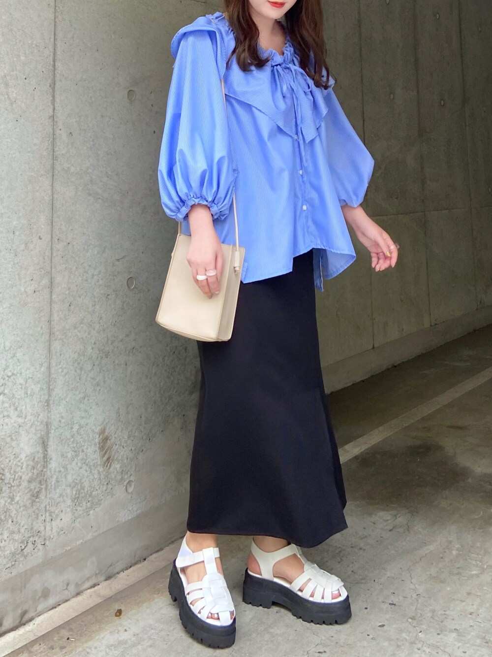 ブルー系のシャツ/ブラウス、ブラック系のスカート、ホワイト系のサンダルを着用したレディースの夏コーディネートの1枚目の写真