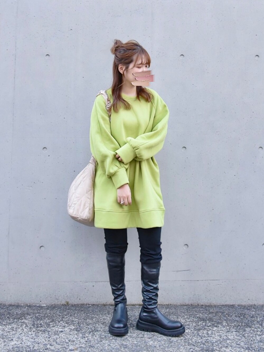グリーン系のスウェット、ブラック系のブーツを着用したレディースの春コーディネートの1枚目の写真