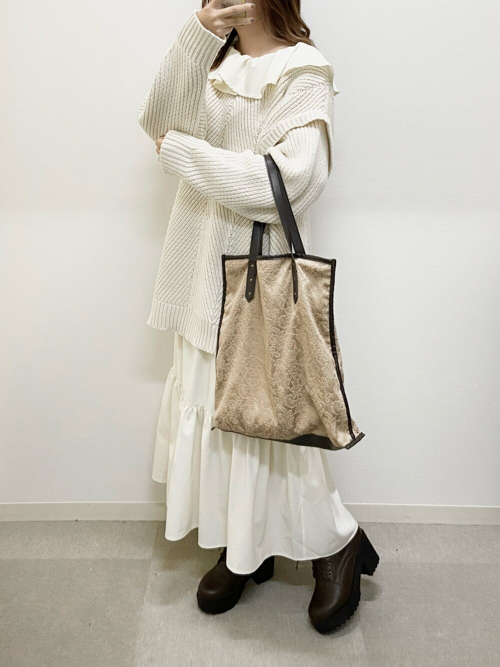 ホワイト系のワンピース、ブラウン系のブーツ、ブラウン系のトートバッグを着用したレディースの冬コーディネートの1枚目の写真