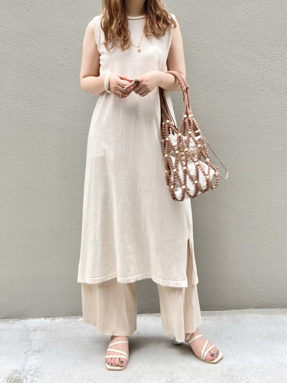 ブラウン系のトートバッグ、ホワイト系のセットアップ、ベージュ系のサンダルを着用したレディースの夏コーディネートの1枚目の写真