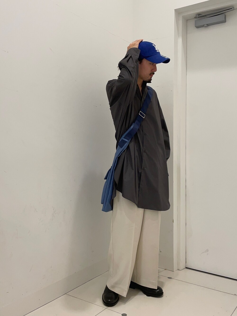 ホワイト系のその他パンツ、グレー系のシャツ/ブラウス、ブルー系のショルダーバッグを着用したメンズの冬コーディネートの1枚目の写真